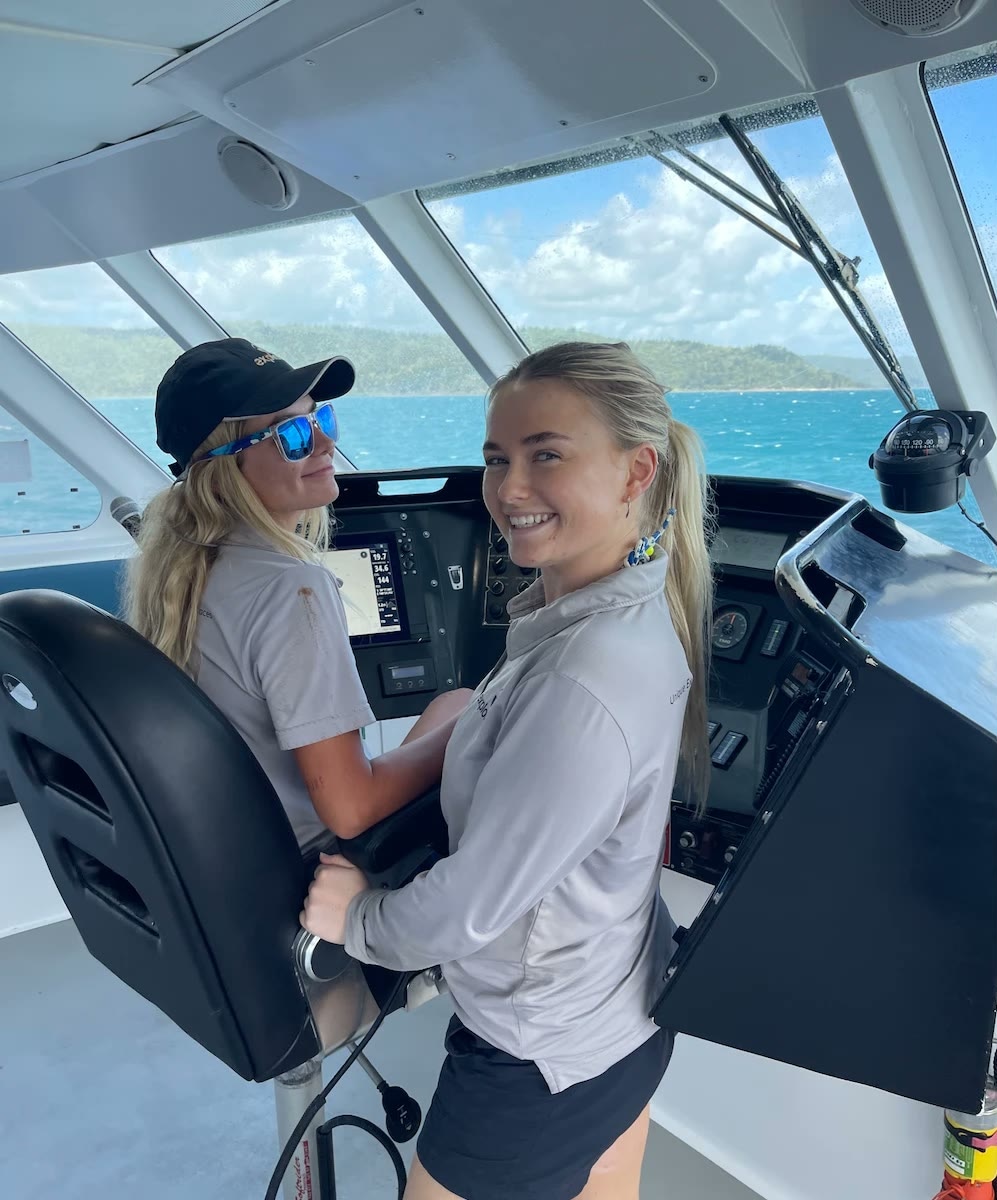 Zoe at the helm of a boat, one of her many jobs