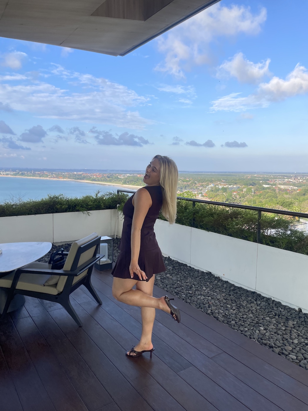 Zoe on a balcony overlooking the coast