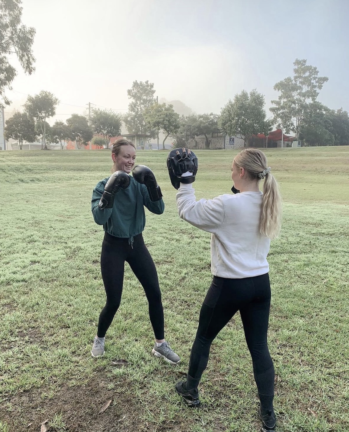 Zoe boxing with a friend in a park